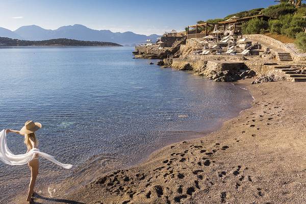 Frau im Bikini am Strand vor dem Minos Palace Hotel & Suites
