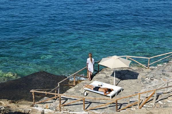 Personen auf der Terrasse des Minos Palace Hotel & Suites mit Blick auf das Meer.