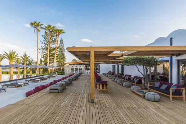 Lounge-Bereich des Minos Palace Hotel & Suites mit Holzdeck, Sitzgelegenheiten und Überdachungen