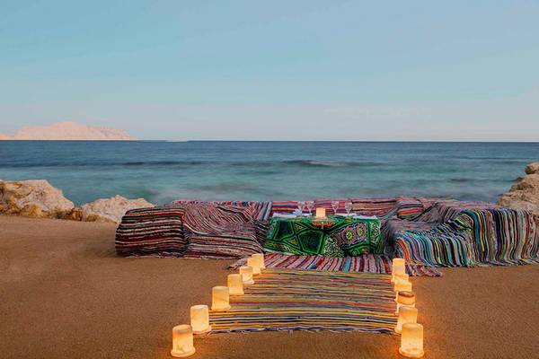 Intimes Abendessen am Strand des Sheraton Sharm Hotel mit Kerzen und Tischdecken.
