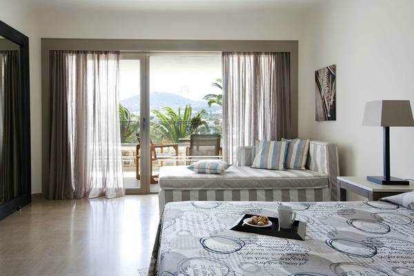 Zimmer im Minos Palace Hotel & Suites mit Blick auf einen Balkon und eine Terrasse.