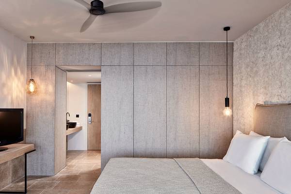 Schlafzimmer des Minos Palace Hotel & Suites mit Fernseher, Bett und Einbauschränken