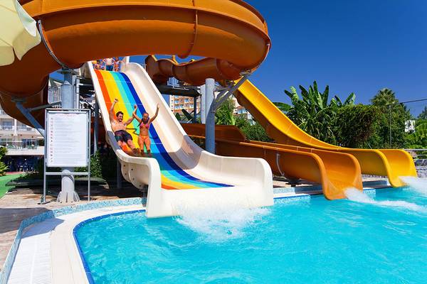 Zwei Personen rutschen auf einer bunten Wasserrutsche im Freien im Hotel Side Sun.