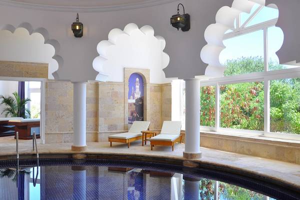 Wellnessbereich im Sheraton Sharm Hotel mit Pool, Liegen und großen Fenstern.