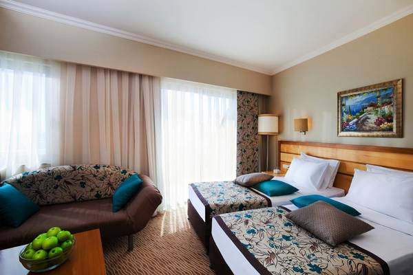 Hotelzimmer mit Sofa und Betten im Side Sun Hotel