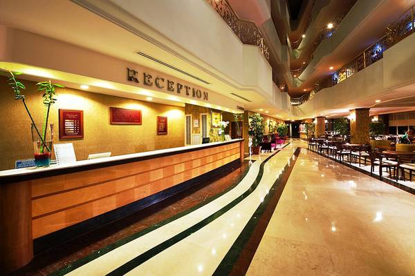 Foto von der Rezeption des Side Sun Hotels mit einer langen Marmortreppe und einem Empfangstresen.