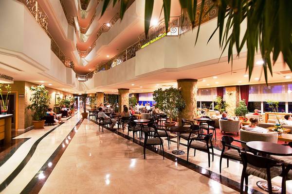Lobby des Side Sun Hotels mit Gästen, Tischen, Stühlen und Pflanzen.