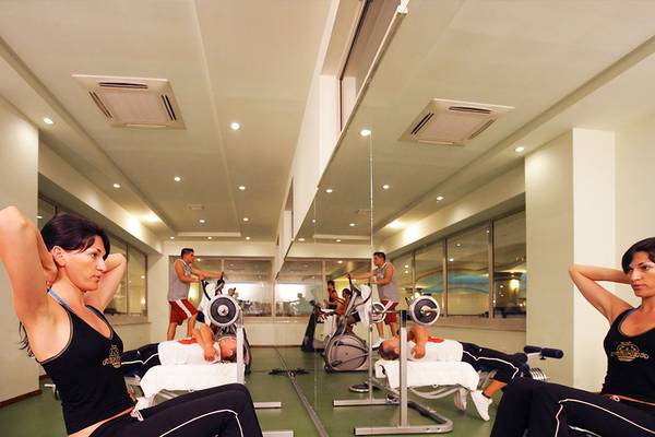 Fitnessstudio-Innenansicht im Side Sun Hotel mit Frauen, die auf Rudergeräten sitzen.