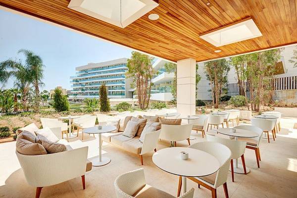 Außenbereich des Hipotels Playa de Palma Palace mit weißen Tischen und Stühlen.