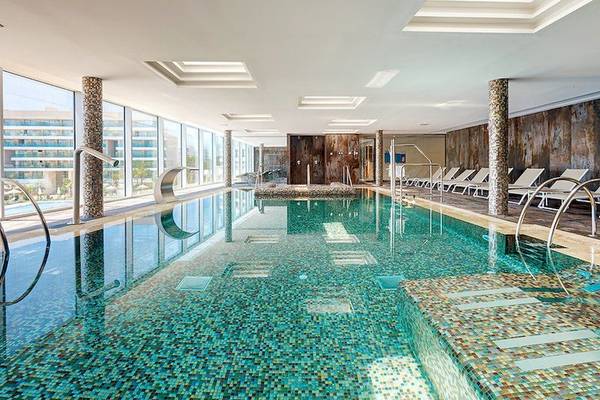 Innenpool des Hipotels Playa de Palma Palace mit Lounge-Bereich und Glaswänden