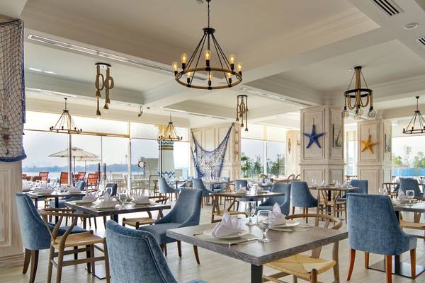 Restaurant im Royal Central Hotel The Palm mit blauen Stühlen und Tischen.