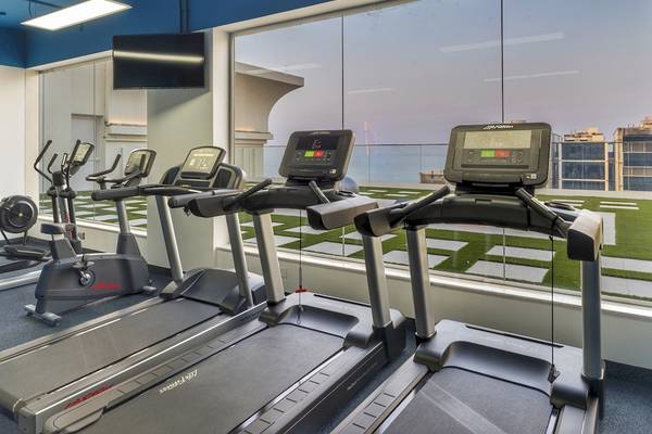Fitnessraum im Royal Central Hotel The Palm mit Blick auf die Skyline.