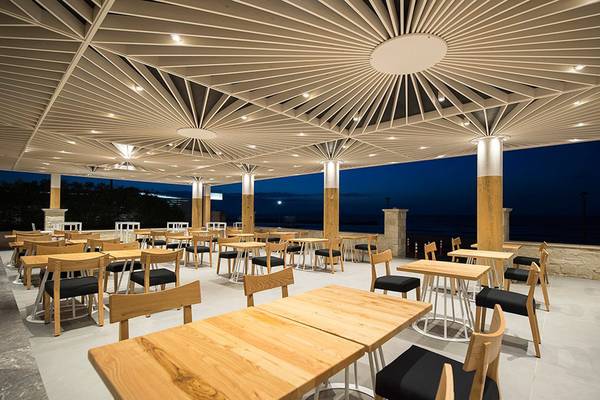 Terrasse des Insula Alba Resort & Spa mit runden Tischen und Stühlen bei Nacht