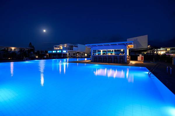 Nachtansicht des Insula Alba Resorts mit beleuchtetem Swimmingpool und Barbereich
