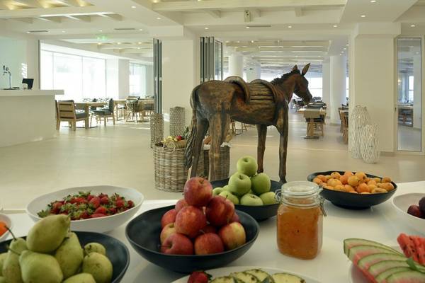Früchtebuffet im Insula Alba Resort & Spa mit einer Holzpferdstatue im Hintergrund.