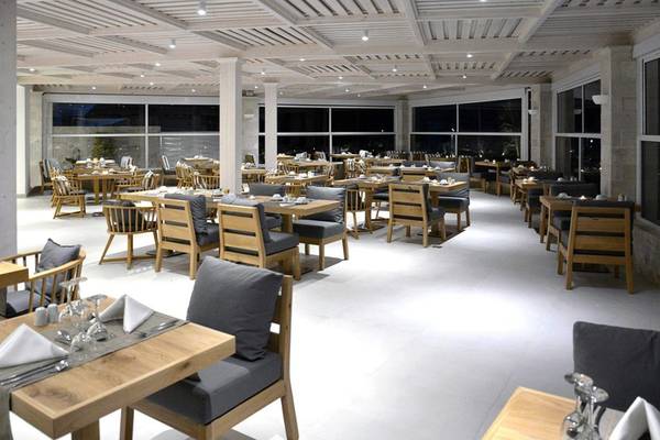 Innenbereich des Insula Alba Resort & Spa mit vielen Holztischen und Stühlen