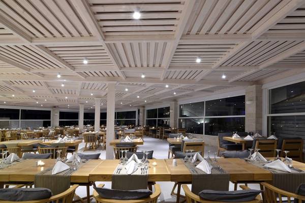 Innenraum des Restaurants im Insula Alba Resort & Spa mit hölzerner Decke und großen Fenstern.
