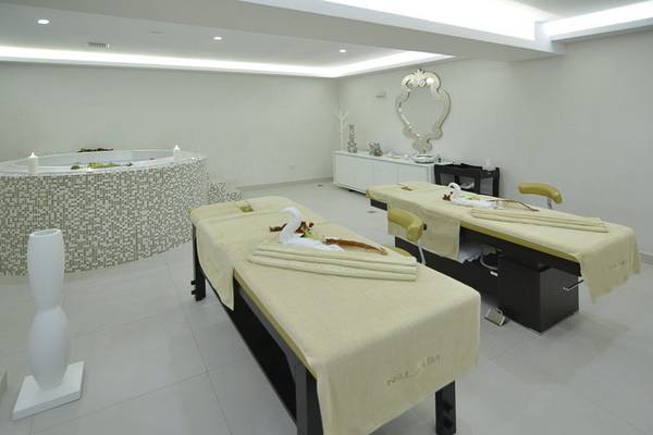 Massagebereich im Insula Alba Resort & Spa mit zwei Massagetischen und einem Whirlpool.