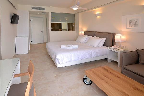 Schlafzimmer im Insula Alba Resort & Spa mit großem Bett, Schreibtisch, Stuhl und Sofa.