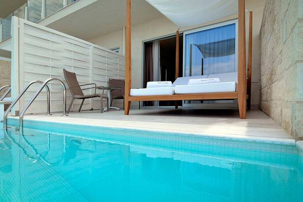 Pool-Terrasse mit Bett und Möbeln im Insula Alba Resort & Spa