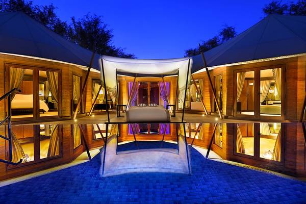 Nachtansicht des Ritz-Carlton Ras Al Khaimah, Al Wadi Desert mit Swimmingpool und Zeltdach.