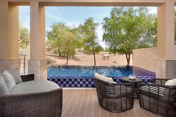 Terrasse im Ritz-Carlton Ras Al Khaimah, Al Wadi Desert mit Blick auf eine Oase und eine Gazelle.