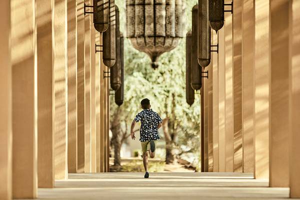 Ein Junge rennt durch den Innenhof des Ritz-Carlton Ras Al Khaimah, Al Wadi Desert