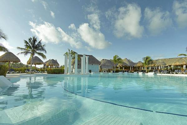 Ein großer Swimmingpool mit weißen Säulen und Sonnenliegen am Grand Palladium White Sand Resort & Spa.