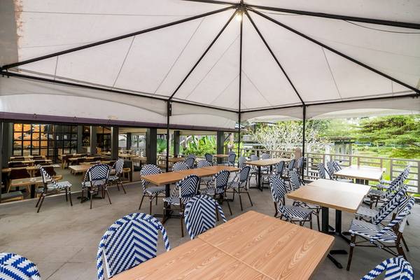 Terrasse des Khao Lak Emerald Beach Resort mit vielen Tischen und Stühlen unter einem Dach.