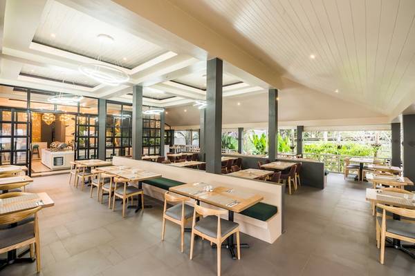 Innenansicht des Restaurants im Khao Lak Emerald Beach Resort & Spa mit geräumigen Tischen und Stühlen.