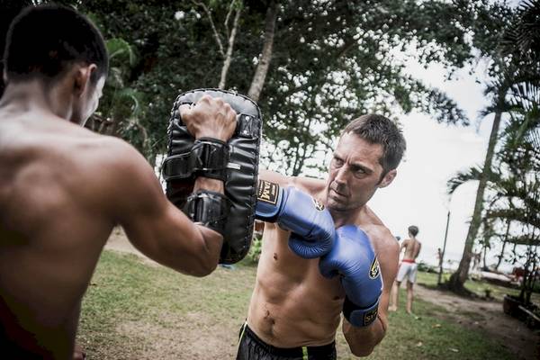 Zwei Männer boxen in einem Freiluft-Trainingslager.