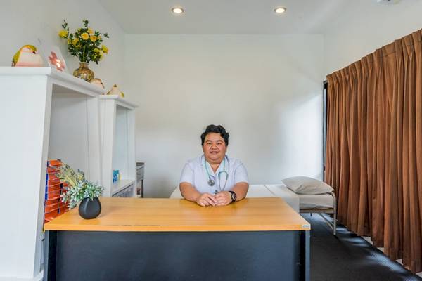 Eine Mitarbeiterin des Khao Lak Emerald Beach Resorts sitzt am Schreibtisch im Hotelzimmer.