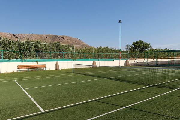 Tennisplatz des Lindos Princess Beach Hotels, umgeben von grünen Zäunen und einer Bank.