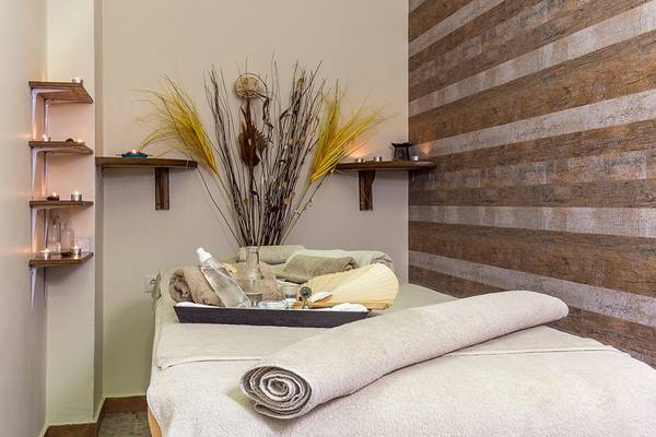 Spa-Behandlungsraum im Lindos Princess Beach Hotel mit Holzwand und Behandlungsliege.