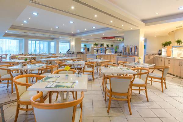 Frühstücksraum des Lordos Beach Hotels mit vielen runden Tischen und Stühlen.
