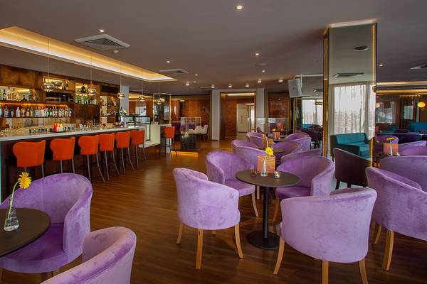 Lounge-Bereich des Lordos Beach Hotels mit violetten Stühlen und einer Theke im Hintergrund.
