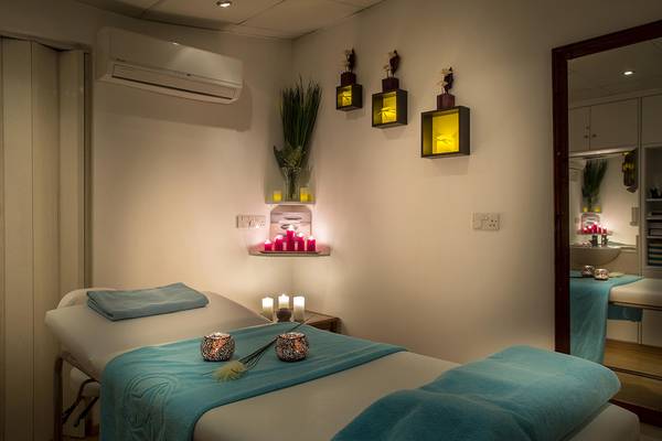 Massageraum im Lordos Beach Hotel mit blauen Handtüchern und Kerzen.