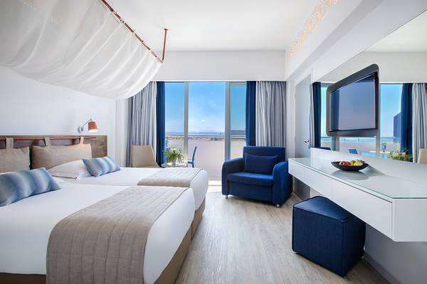 Doppelzimmer im Lordos Beach Hotel mit zwei Betten und Aussicht auf das Meer.