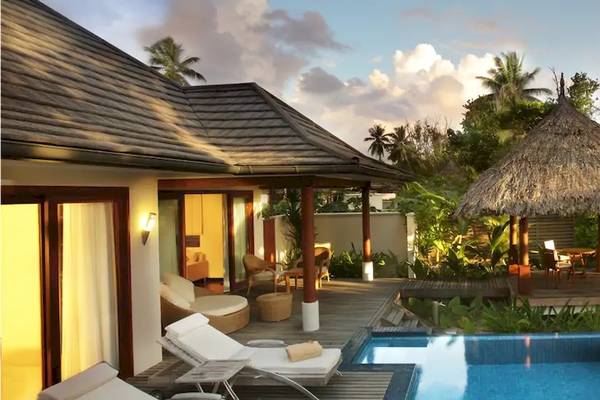 Außenbereich der Coco de Mer Pool Villa mit Swimmingpool, Hängematten und Pavillon.