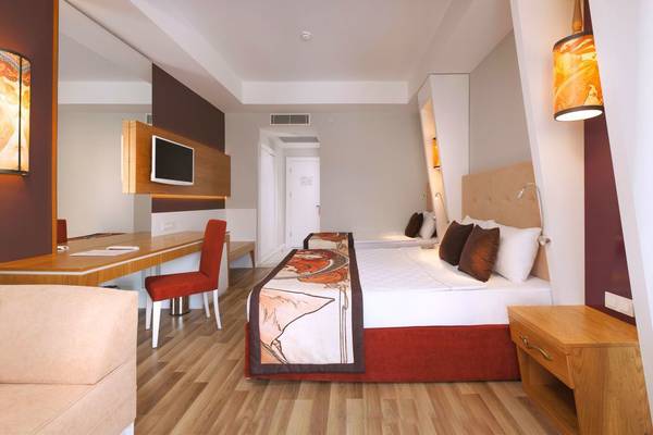 Innenansicht eines Hotelzimmers im Side Orange Palace mit zwei Betten, Schreibtisch und Möbeln.