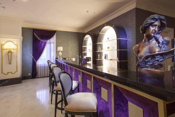 Innenansicht der Bar im Side Orange Palace Hotel mit Marmortheke, Stühlen und Statue.