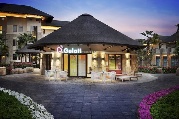 Außenansicht des Gelati Eiscafés im Sofitel Dubai The Palm mit Dach und Tischen draußen