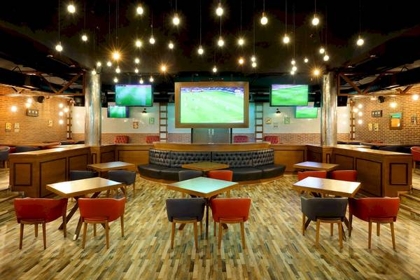 Innenbereich der Sportbar im Grand Palladium White Sand Resort mit Fernsehern und Sitzbereichen.