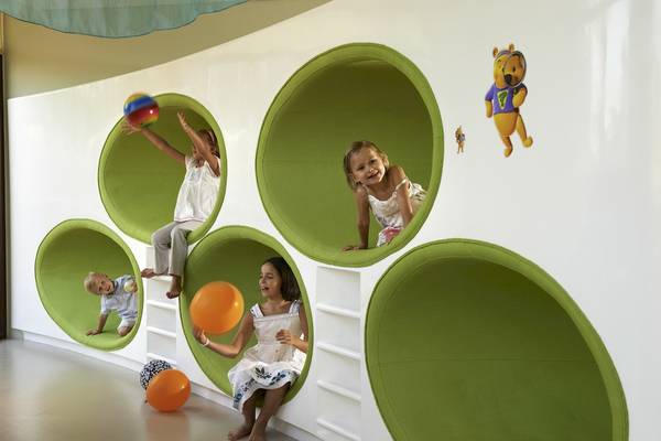 Kinder spielen in einem grünen, runden Spielzimmer im Sofitel Dubai The Palm.