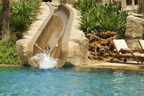 Ein Kind rutscht von einer Wasserrutsche in den Pool im Sofitel Dubai The Palm.