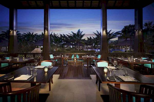 Innenansicht des Restaurants im Sofitel Dubai The Palm mit Blick auf die Palmen und den Himmel bei Nacht