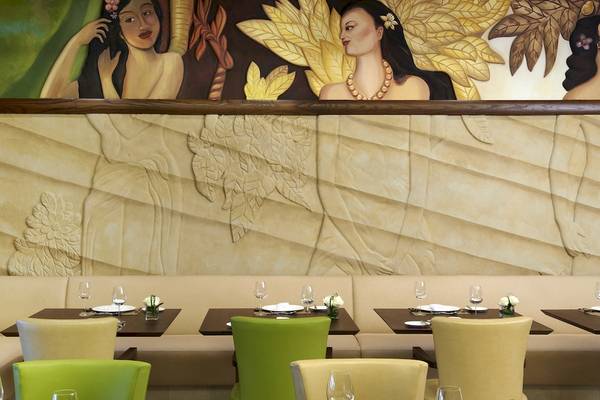 Innenansicht des Restaurants im Sofitel Dubai The Palm mit kunstvollen Wandmalereien und gedeckten Tischen.