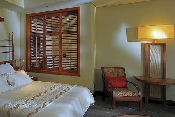 Hotelzimmer im Trou aux Biches Beachcomber Golf Resort & Spa mit Bett, Kissen, Schrank und Fenstern.