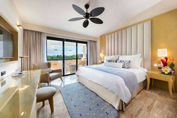 Schlafzimmer im Grand Palladium White Sand Resort & Spa mit großem Bett, Balkonzugang und modernen Möbeln.