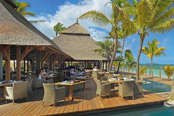 Außenterrasse des Trou aux Biches Beachcomber Golf Resort & Spa mit Tischen und Stühlen am Pool